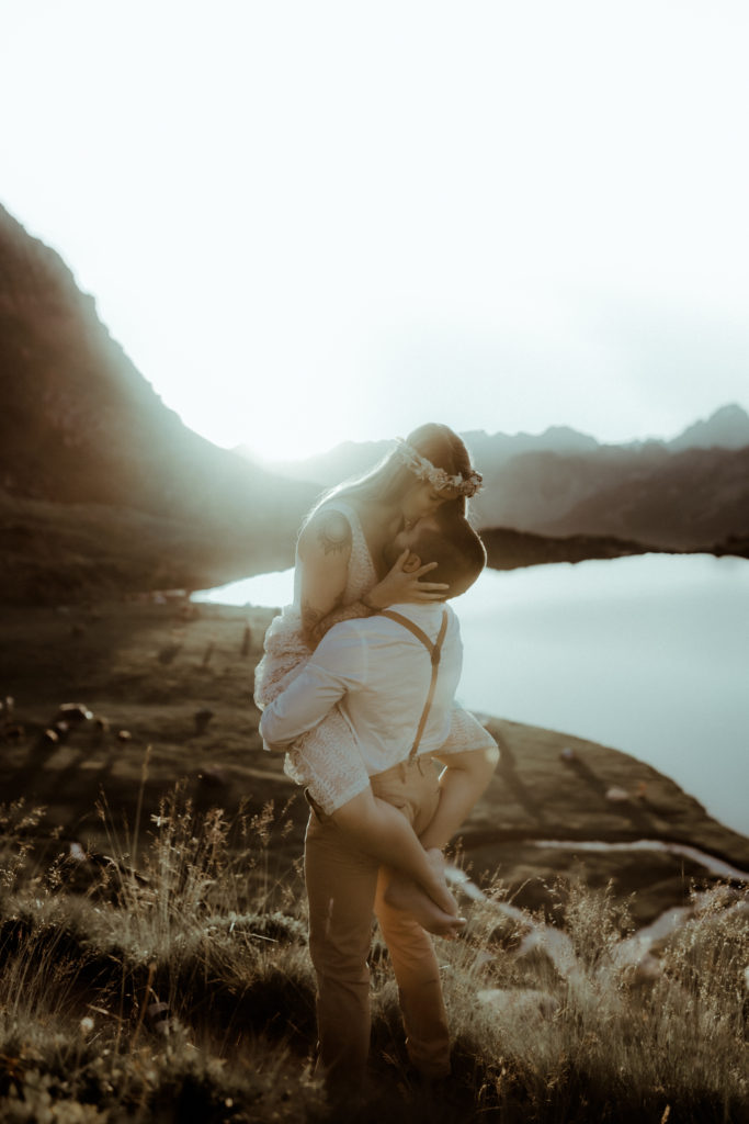 Le couple s'embrasse passionnément avec la belle lumière dorée du coucher de soleil. Une photo capturé par la photographe de couple Gaétane Glize dans les Pyrénées aux lacs d'Ayous.