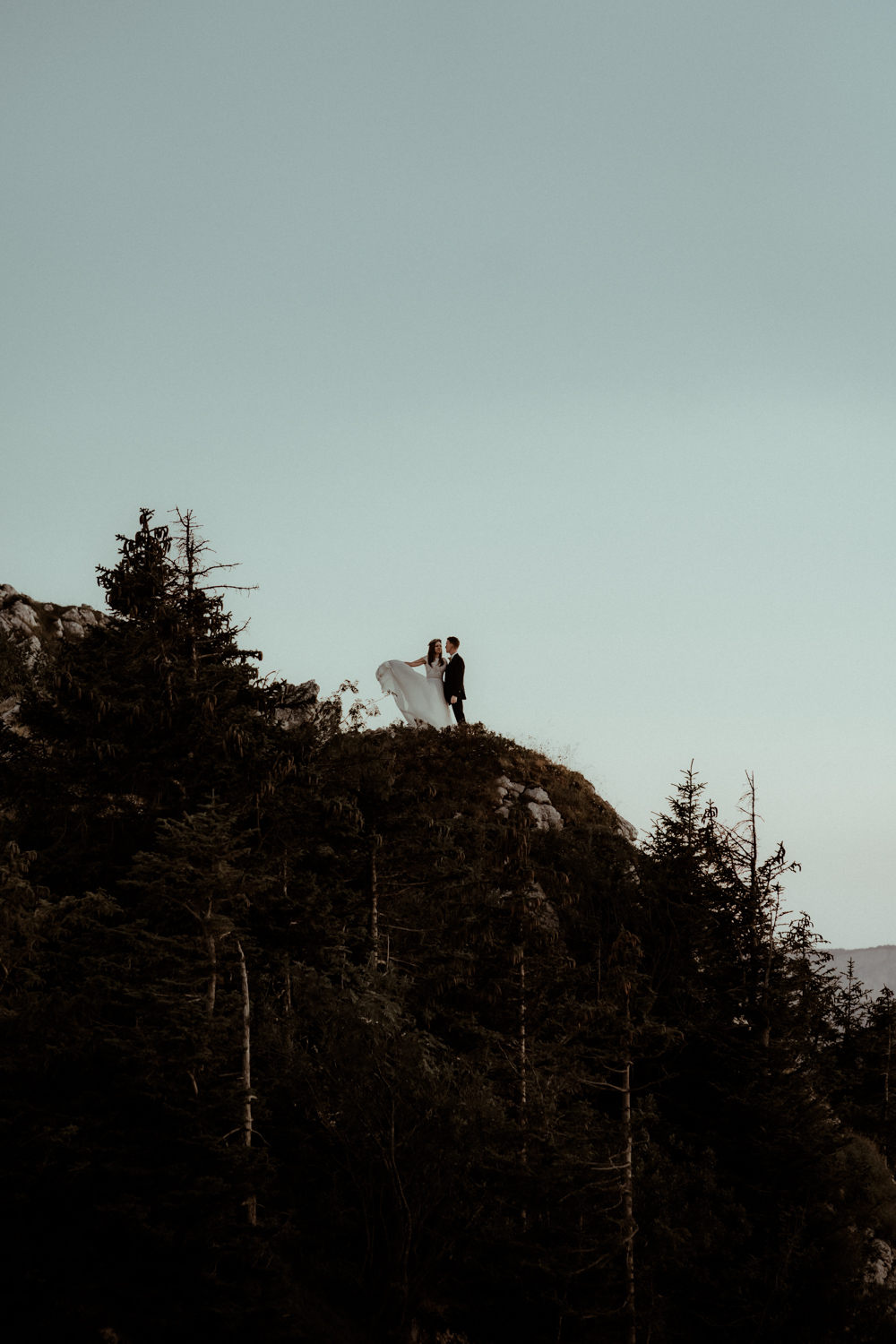 Le couple de mariés dansent au sommet d'une montagne pour célébrer leur mariage à l'occasion de leur elopement dans les Pyrénées avec leur photographe Gaétane Glize.