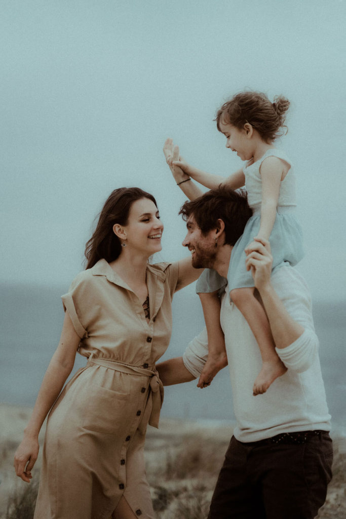une famille danse ensemble et partage un moment de fun pendant leur séance photo dans les landes à Labenne avec Gaétane Glize
