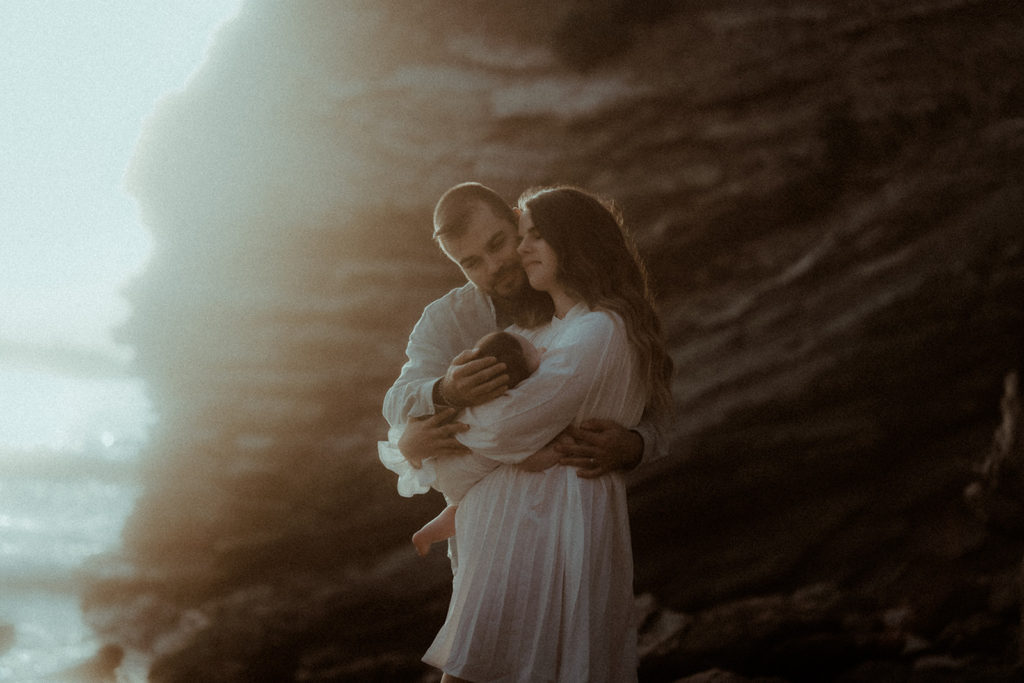 Une famille avec un bébé se font un calin sur une plage du pays basque au coucher de soleil. Un moment de tendresse capturé par la photographe de famille Gaétane Glize.