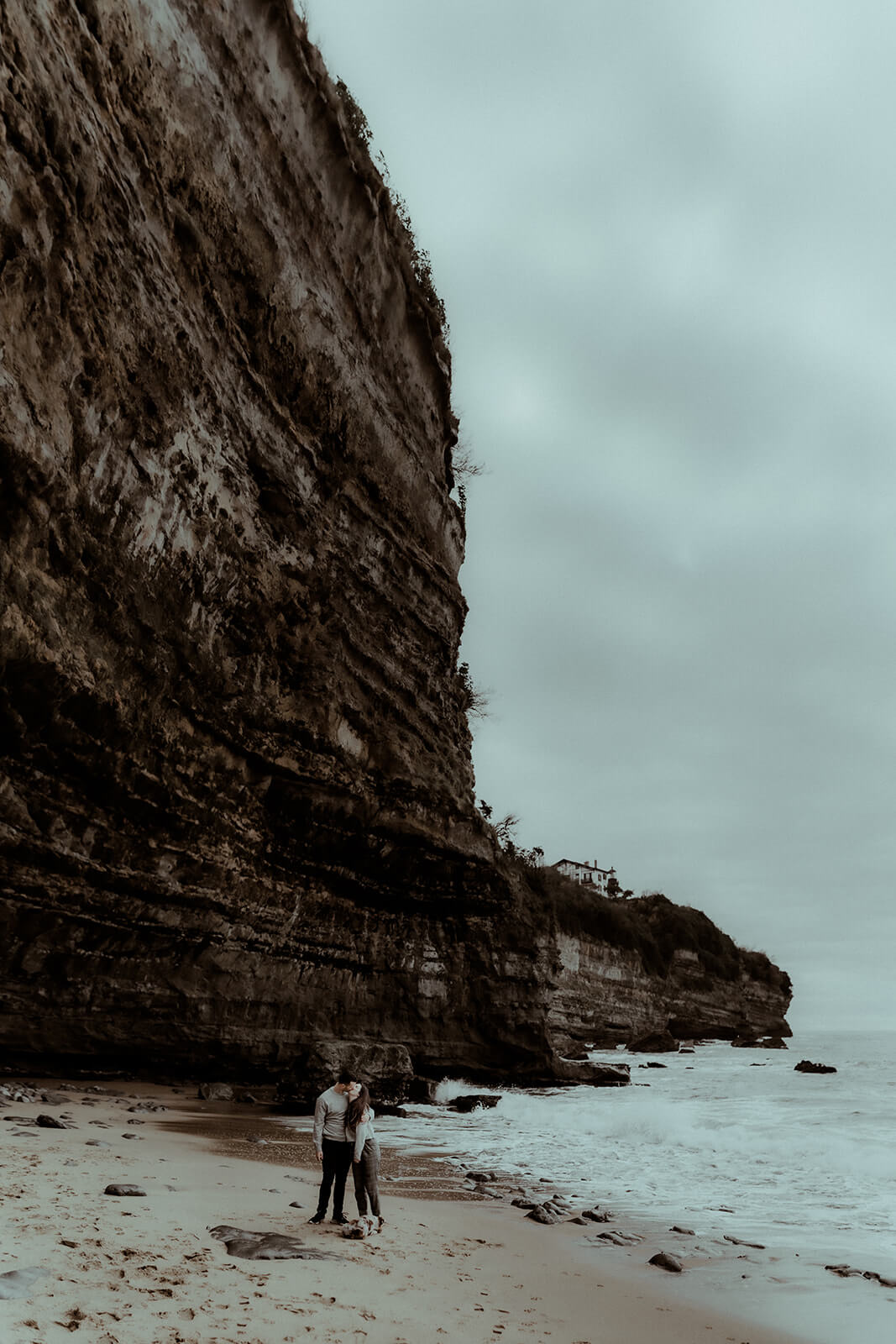 Un couple s'embrasse au pied des falaises d'Anglet au Pays Basque, une scène capturée par Gaétane Glize, photographe couple landes et pays basque