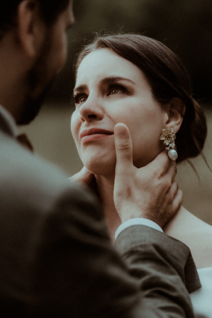 La mariée pleure des larmes d'émotion en regardant son mari dans les yeux. Elle est submergée par tout l'amour ressenti. Un moment pris pendant leur séance couple le jour de leur mariage par la photographe de mariage Gaétane Glize.