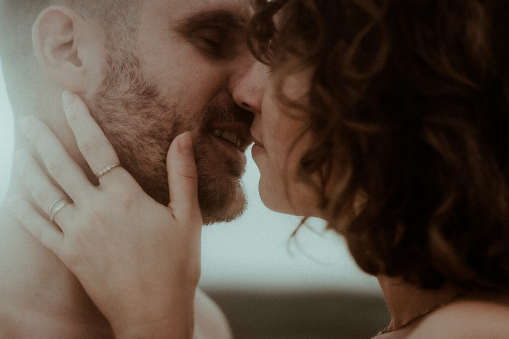 Un couple est sur le point de s'embrasser, la femme tient le visage de son mari dans ses mains. Un moment très doux capturé par Gaétane Glize, photographe couple landes.